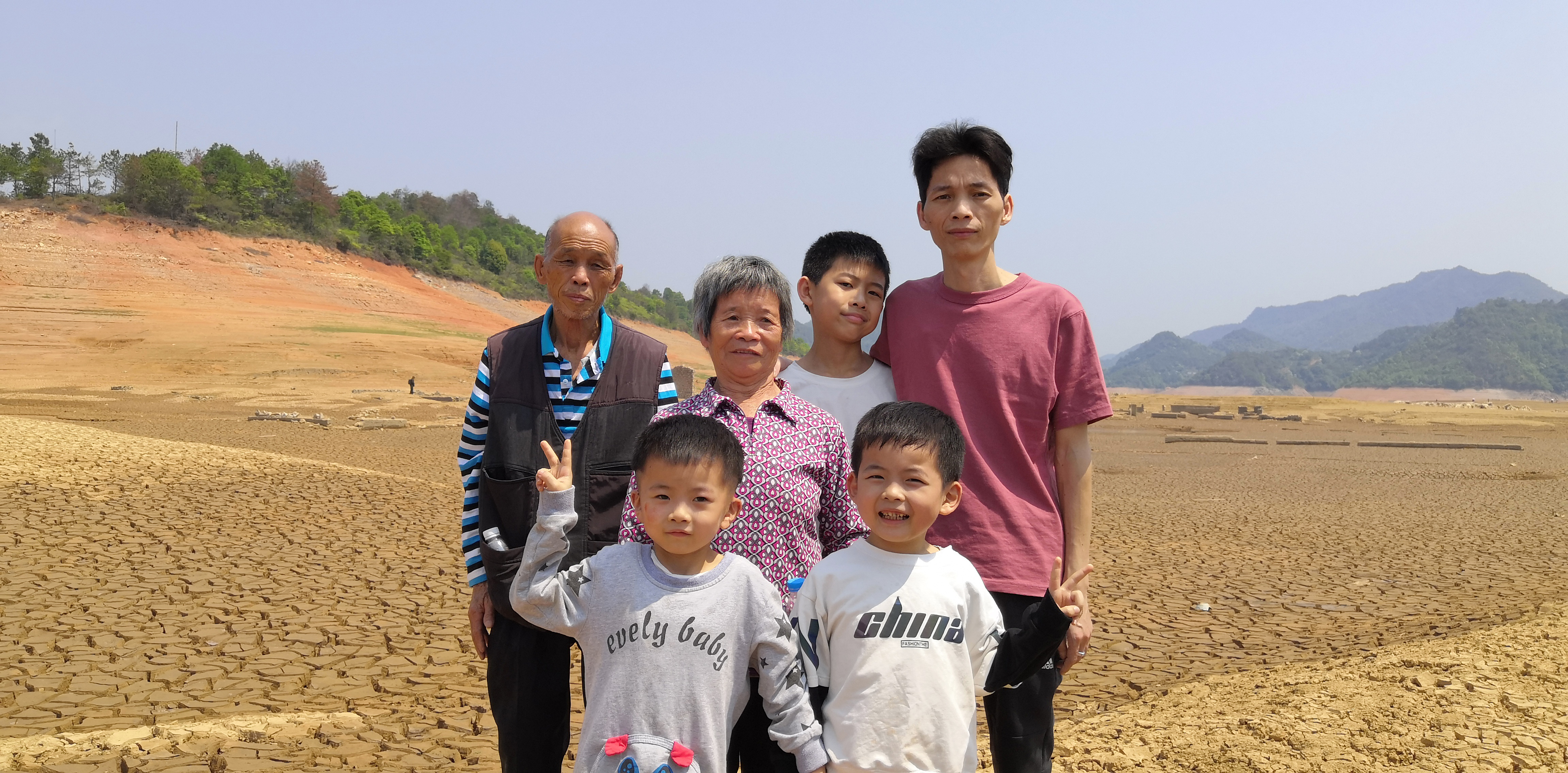 △杨运妹祖孙三代人在老宅旧址前合影。